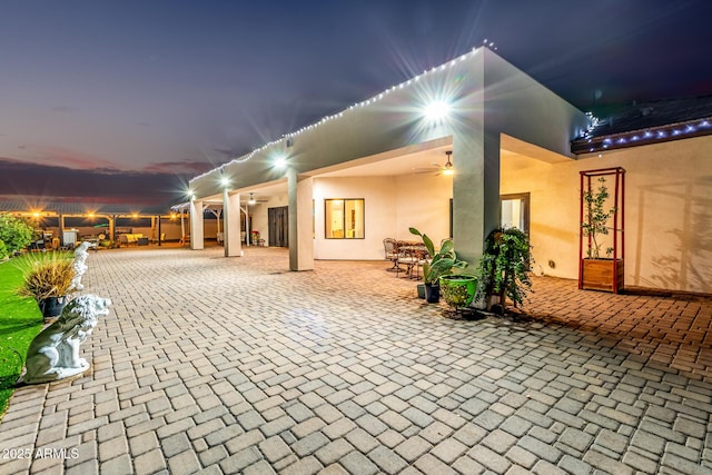 rear view of property featuring stucco siding, a patio, and ceiling fan