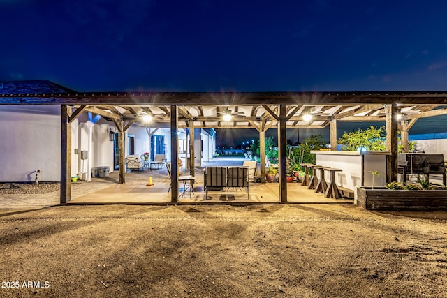 patio at twilight with a pergola and outdoor dry bar