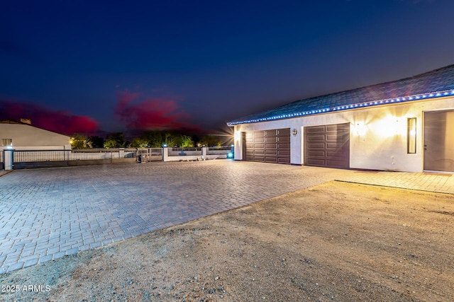 exterior space featuring decorative driveway and fence