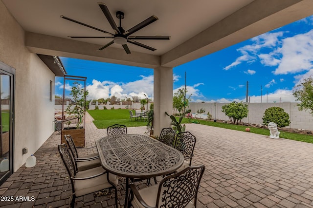 view of patio with outdoor dining area, a fenced backyard, and ceiling fan