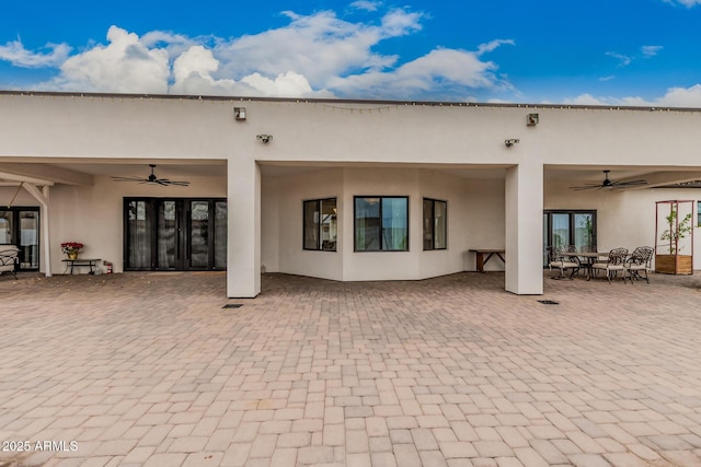 back of property with a patio, a ceiling fan, and stucco siding