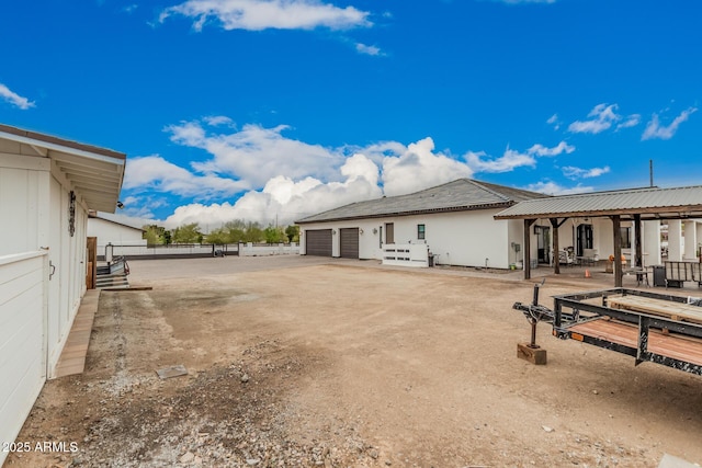 exterior space featuring a garage, a patio area, driveway, and fence