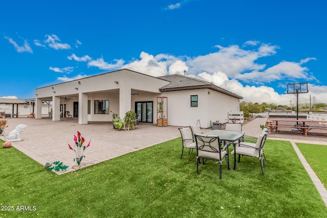 back of property featuring ceiling fan, stucco siding, french doors, a yard, and a patio