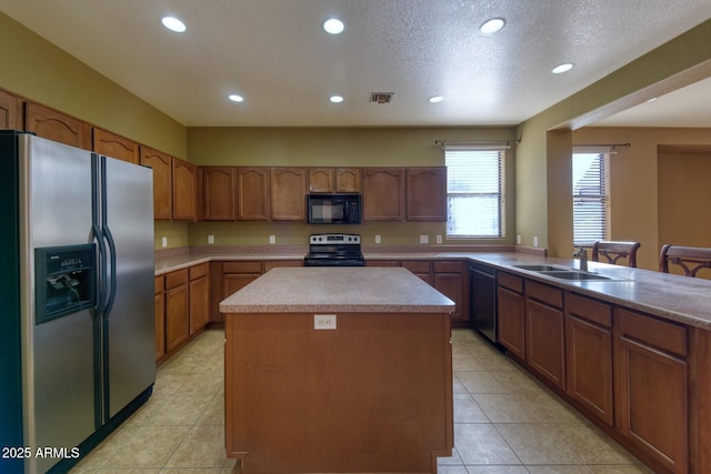 kitchen featuring a sink, stainless steel appliances, visible vents, recessed lighting, and a kitchen island