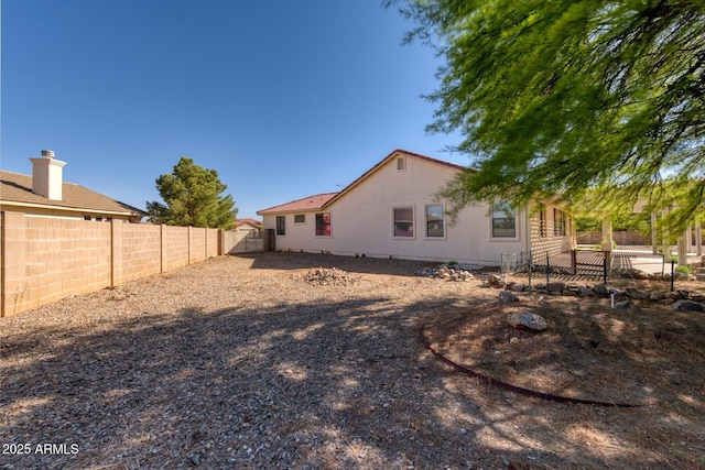 rear view of property featuring a fenced backyard