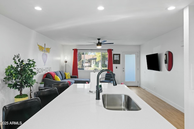 kitchen featuring ceiling fan, sink, and light hardwood / wood-style floors