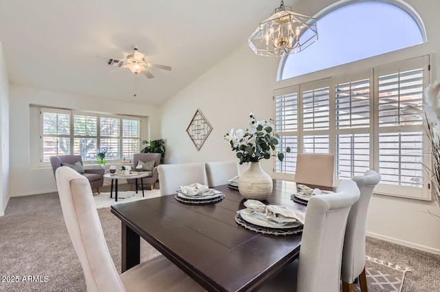 dining room with carpet floors, ceiling fan with notable chandelier, and lofted ceiling