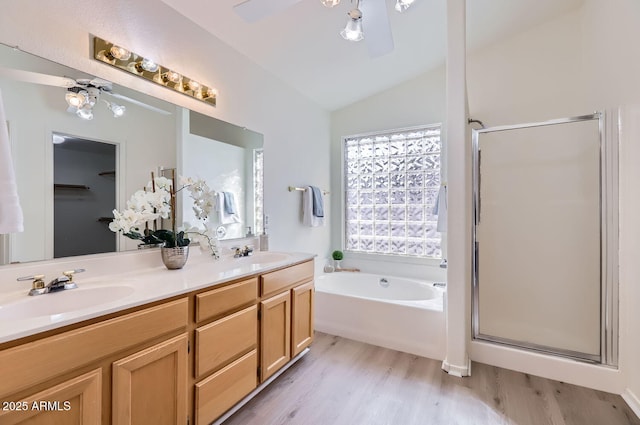 bathroom featuring hardwood / wood-style floors, lofted ceiling, vanity, ceiling fan, and independent shower and bath