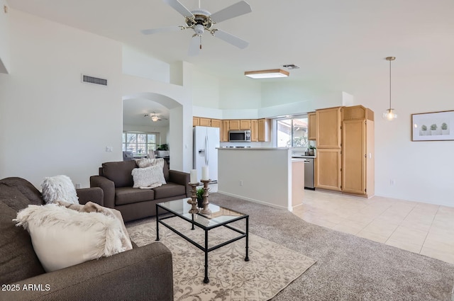 living room featuring ceiling fan, a healthy amount of sunlight, light colored carpet, and high vaulted ceiling