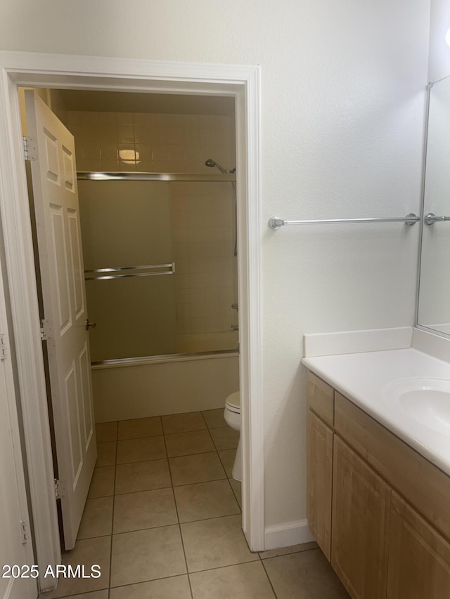 7575 E Indian Bend Rd Unit 1100, Scottsdale, AZ 85250 - bathroom with tile patterned flooring, toilet, vanity, enclosed tub / shower combo, and baseboards