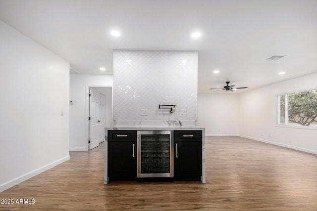 bar with light hardwood / wood-style flooring, beverage cooler, and ceiling fan