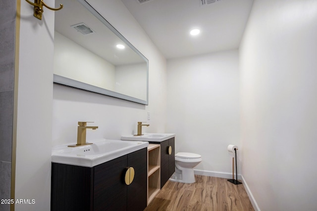 bathroom with hardwood / wood-style flooring, vanity, and toilet