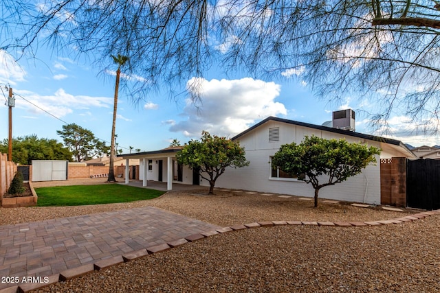 back of property with a patio area, a storage unit, and a lawn