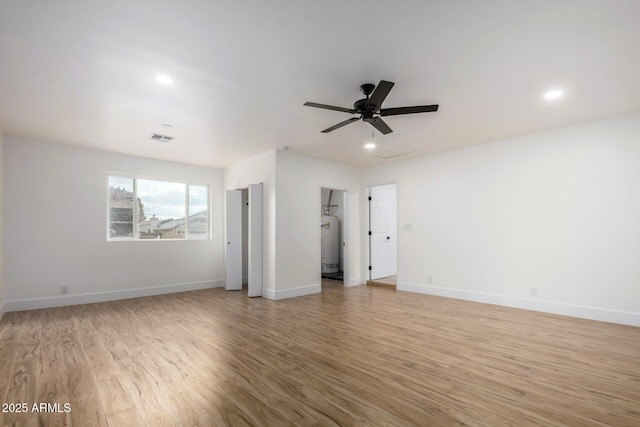 unfurnished bedroom with water heater, ceiling fan, and light hardwood / wood-style floors