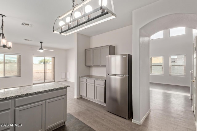 2834 N Paisley Ln, Casa Grande, AZ 85122 - kitchen with visible vents, gray cabinets, freestanding refrigerator, and wood finished floors