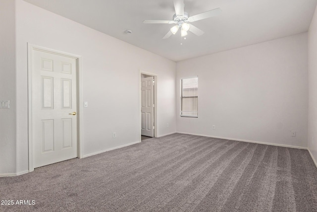 carpeted empty room featuring a ceiling fan and baseboards