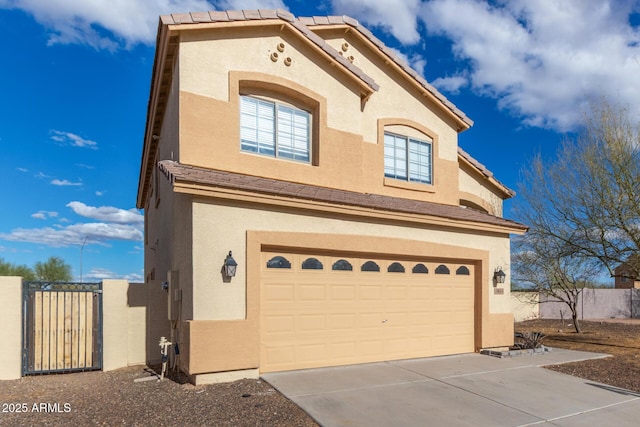 view of front of house with a gate, stucco siding, concrete driveway, a garage, and a tiled roof