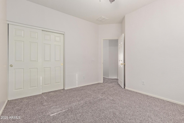 unfurnished bedroom featuring visible vents, carpet floors, baseboards, and a closet