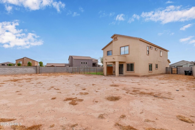 back of property featuring stucco siding and a fenced backyard