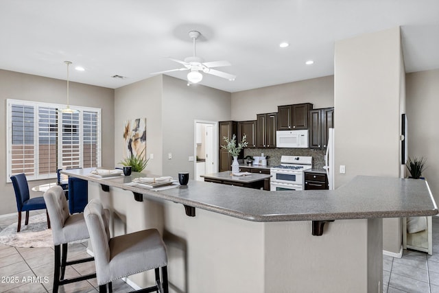 2260 E Binner Dr, Chandler, AZ 85225 - kitchen featuring a center island, white appliances, a breakfast bar, and light tile patterned floors