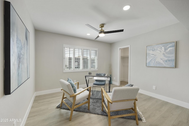 sitting room with ceiling fan and light wood-type flooring