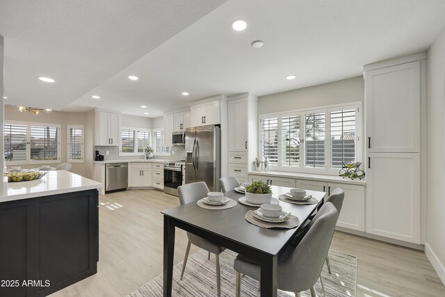 dining area with sink and light hardwood / wood-style flooring