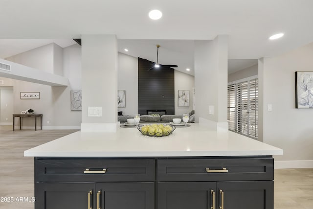 kitchen featuring lofted ceiling, kitchen peninsula, and light wood-type flooring