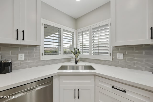 kitchen with dishwasher, sink, white cabinets, and decorative backsplash