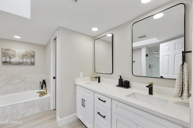 bathroom featuring vanity, plus walk in shower, and hardwood / wood-style floors