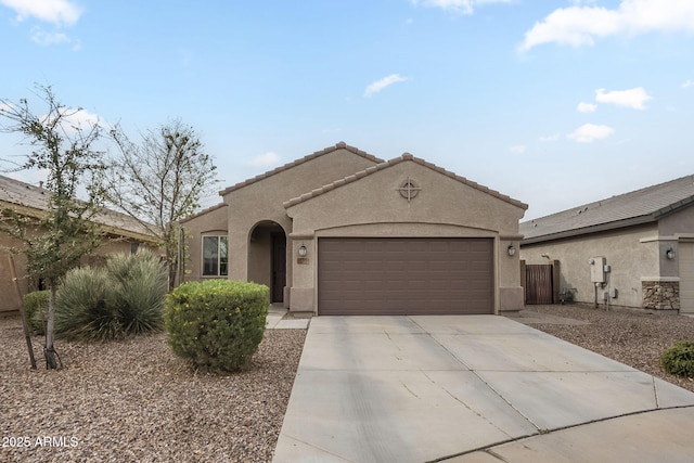 mediterranean / spanish-style house with stucco siding, a garage, concrete driveway, and a tiled roof