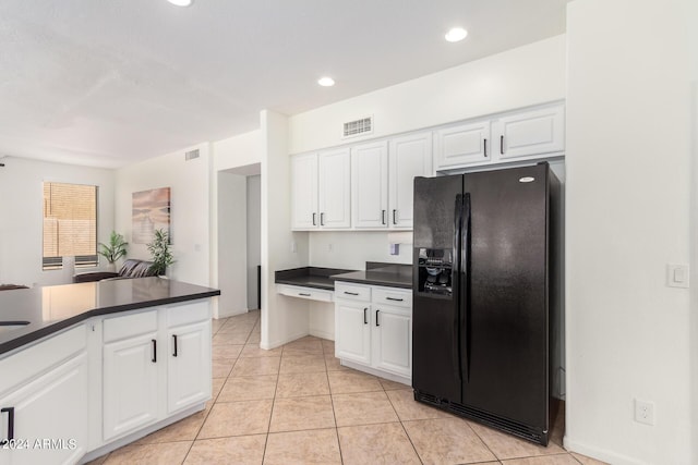 kitchen with light tile patterned floors, black refrigerator with ice dispenser, and white cabinets