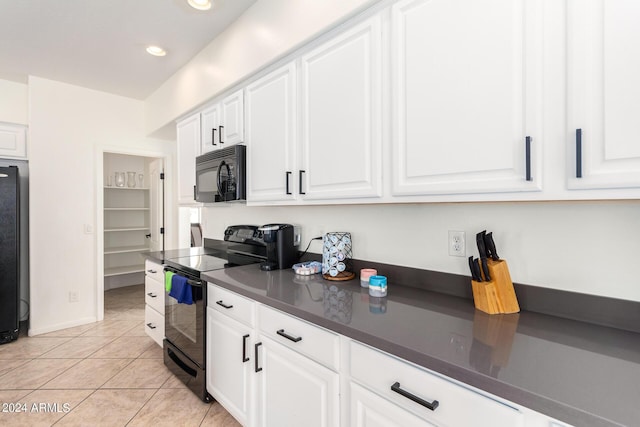 kitchen featuring light tile patterned flooring, white cabinets, and black appliances