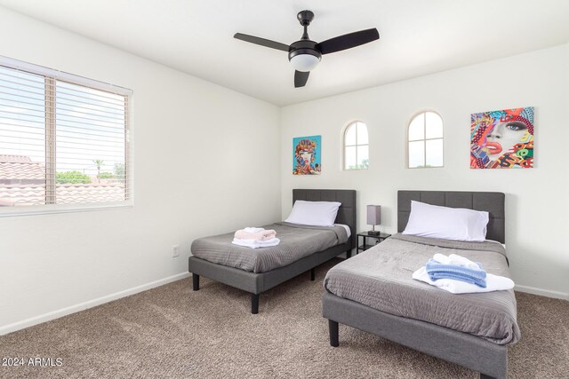 bedroom with ceiling fan, carpet flooring, and multiple windows