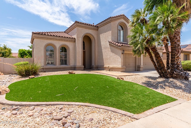 mediterranean / spanish house with a garage and a front yard