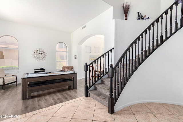 entryway with light tile patterned flooring and high vaulted ceiling