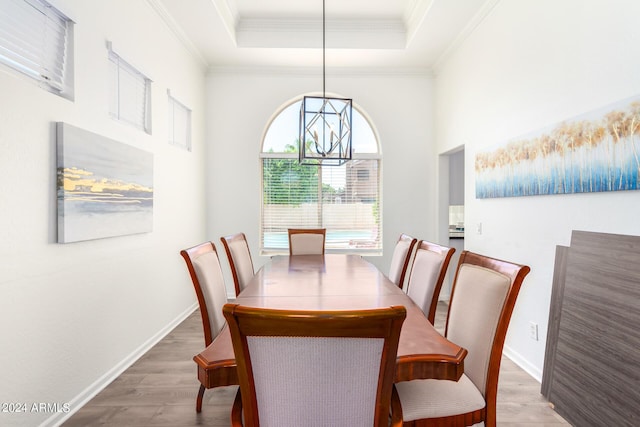 dining space featuring crown molding, a tray ceiling, and dark hardwood / wood-style flooring