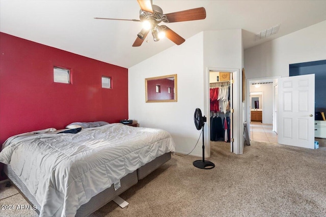 carpeted bedroom with a walk in closet, vaulted ceiling, a closet, and ceiling fan