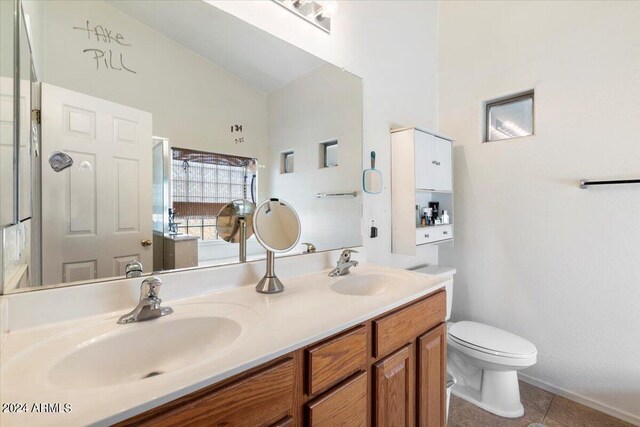 bathroom with vanity, vaulted ceiling, tile patterned floors, and toilet