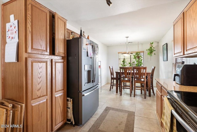 kitchen featuring stainless steel refrigerator with ice dispenser, light tile patterned floors, electric range, and decorative light fixtures