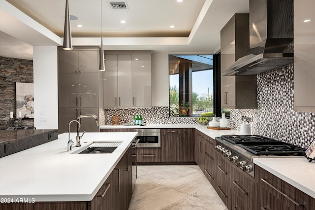 kitchen featuring backsplash, wall chimney range hood, sink, and stainless steel appliances