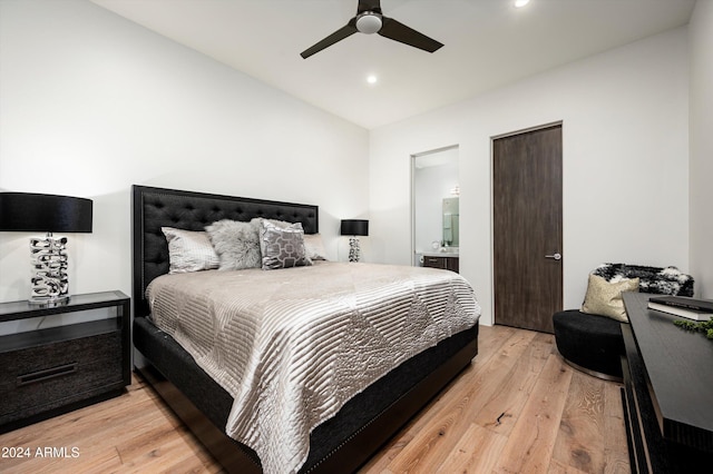 bedroom featuring light wood-type flooring, ceiling fan, and connected bathroom