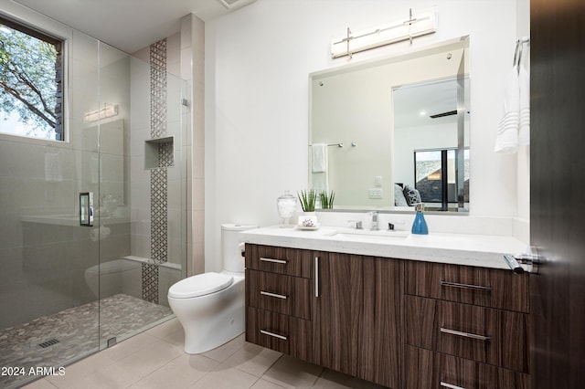 bathroom with tile patterned floors, vanity, a shower with shower door, and toilet