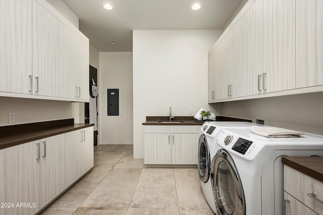 clothes washing area featuring cabinets, electric panel, sink, washing machine and dryer, and light tile patterned floors