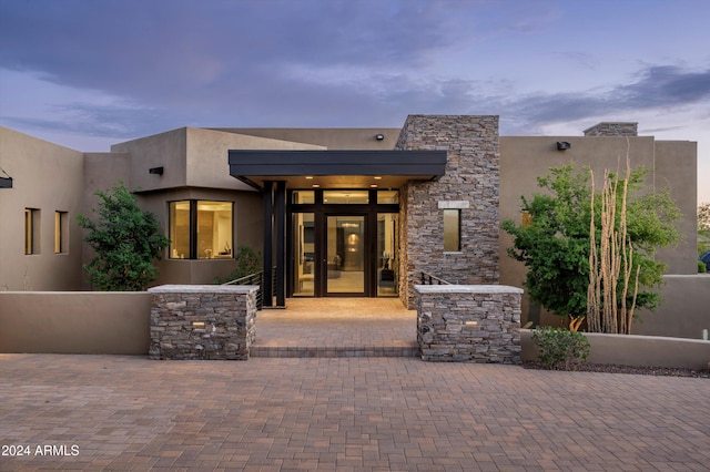 exterior entry at dusk with a patio area