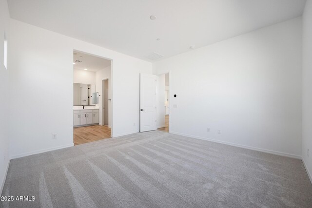 28266 N 134th Dr, Peoria, AZ 85383 - unfurnished bedroom featuring baseboards, light carpet, and ensuite bath