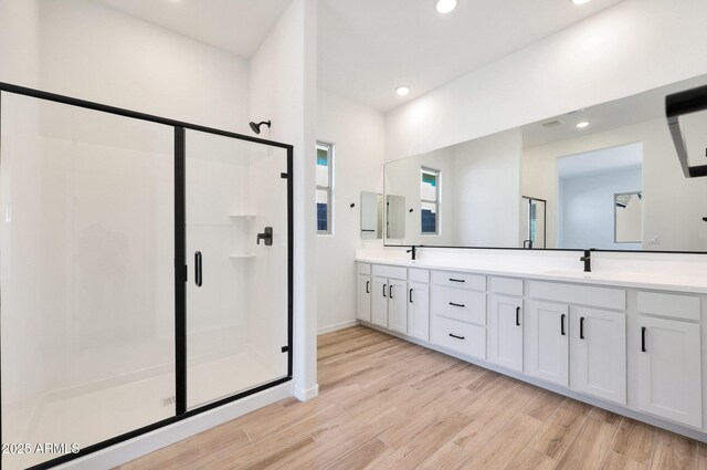 28266 N 134th Dr, Peoria, AZ 85383 - full bath featuring double vanity, recessed lighting, a stall shower, wood finished floors, and a sink