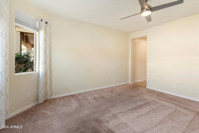 carpeted spare room with ceiling fan