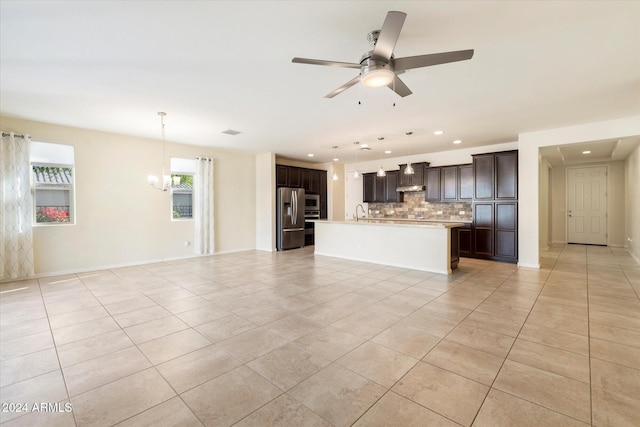 unfurnished living room featuring ceiling fan with notable chandelier, light tile patterned flooring, and sink