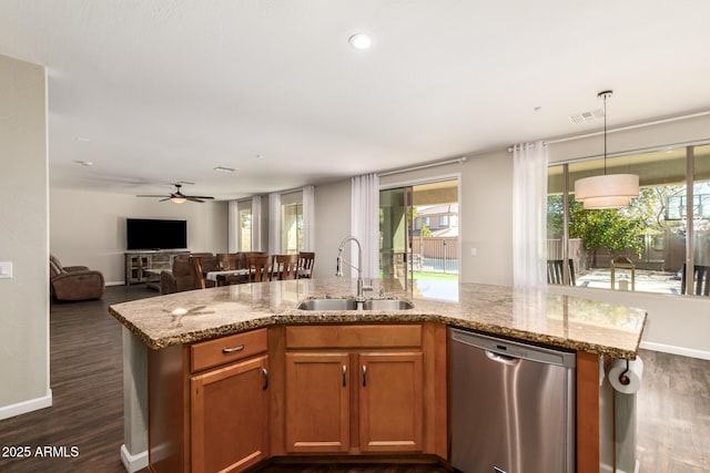 kitchen featuring dark hardwood / wood-style floors, pendant lighting, dishwasher, sink, and light stone counters