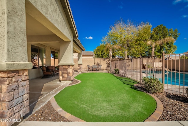 view of yard with a fenced in pool and a patio